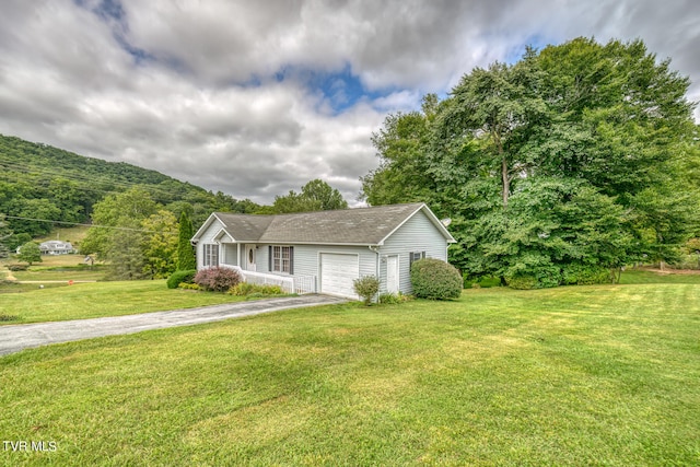 view of front of house featuring a mountain view, a front lawn, and a garage