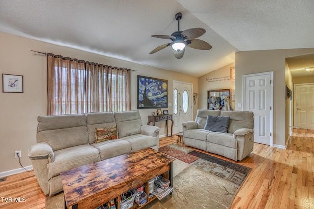 living room featuring lofted ceiling, a textured ceiling, light wood-type flooring, and ceiling fan