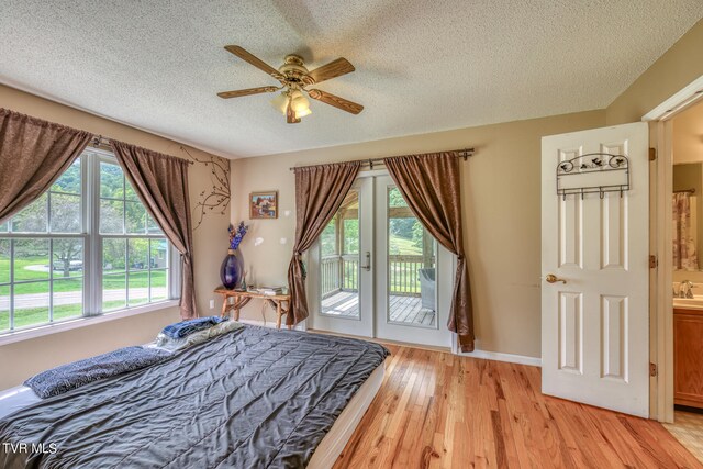 bedroom with light hardwood / wood-style floors, access to outside, a textured ceiling, and ceiling fan