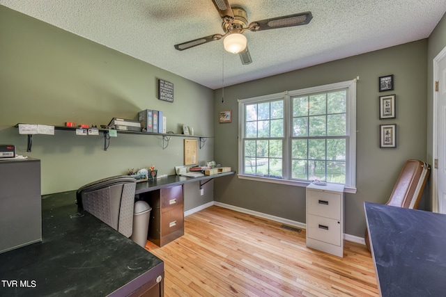 office space with a textured ceiling, light wood-type flooring, and ceiling fan