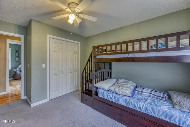 bedroom featuring a closet, ceiling fan, a textured ceiling, and light colored carpet