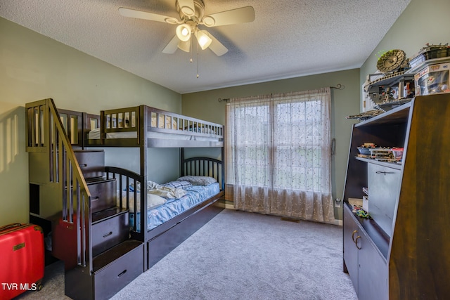 carpeted bedroom featuring a textured ceiling and ceiling fan