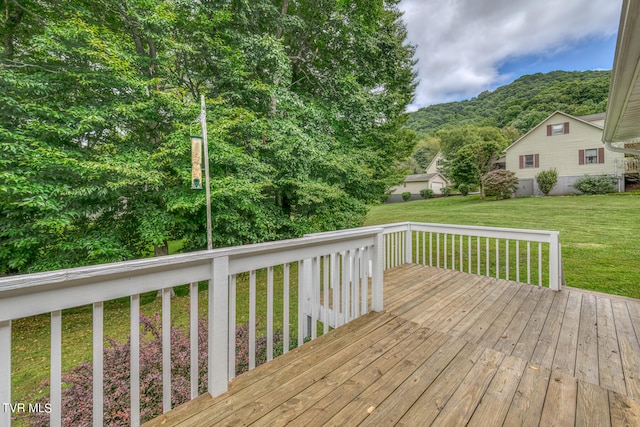 deck with a mountain view and a yard