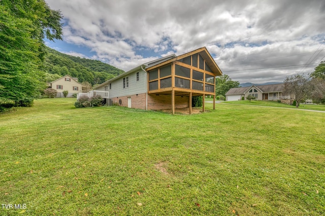 105 Buckner Dr, Roan Mountain, TN 37687 - rear view of house with a lawn and a sunroom