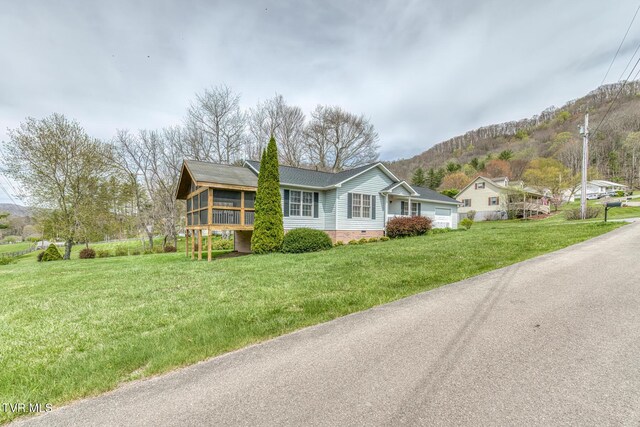 105 Buckner Dr, Roan Mountain, TN 37687 - single story home featuring a shingled roof, crawl space, a sunroom, a front yard, and a mountain view