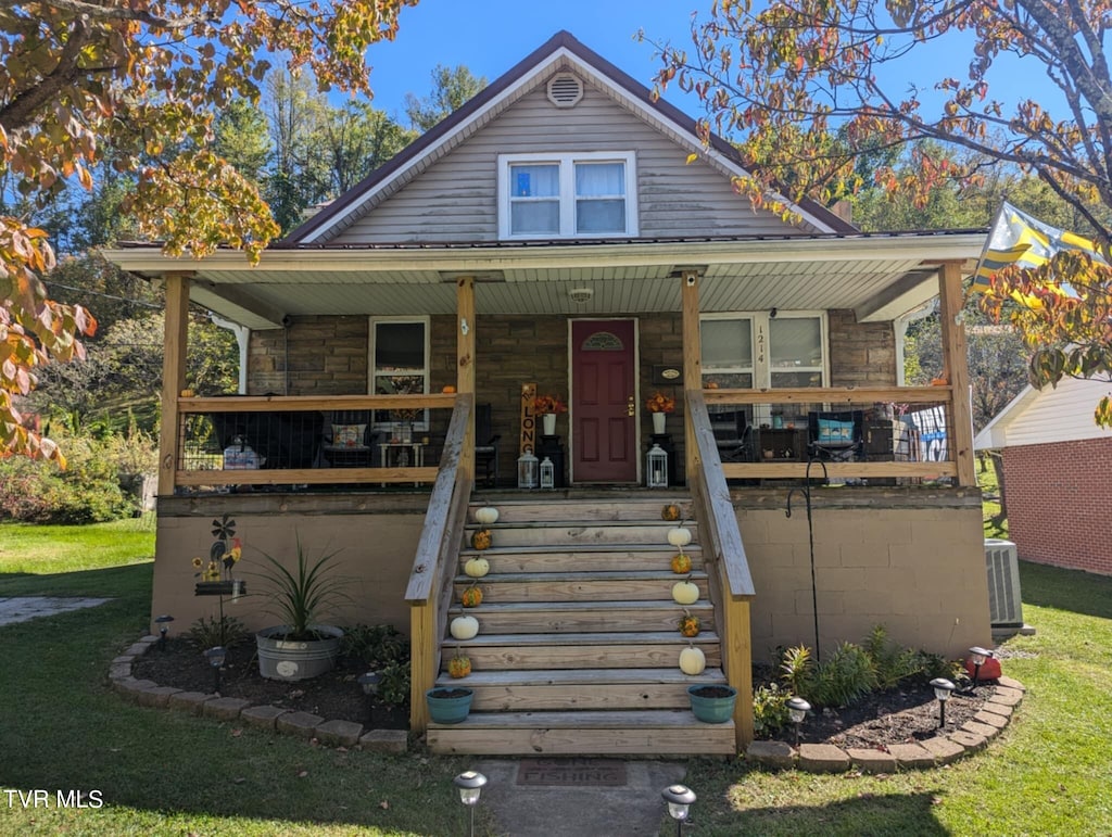 view of front of house with a porch, a front lawn, and cooling unit