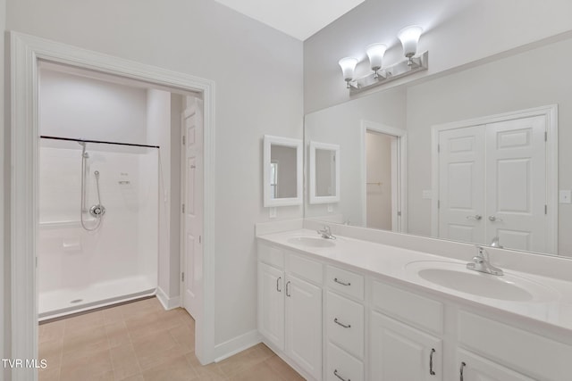 bathroom featuring tile patterned flooring, vanity, and walk in shower