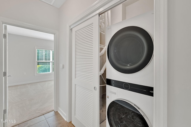 laundry room with stacked washer / dryer and light carpet