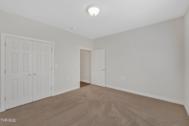 unfurnished bedroom featuring carpet flooring and a closet