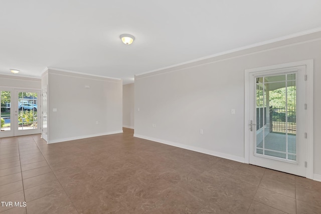 tiled empty room featuring ornamental molding and a wealth of natural light