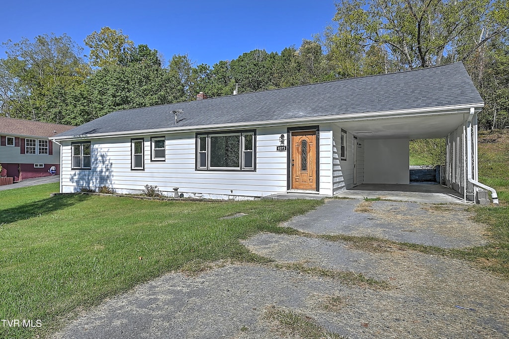 single story home featuring a carport and a front lawn