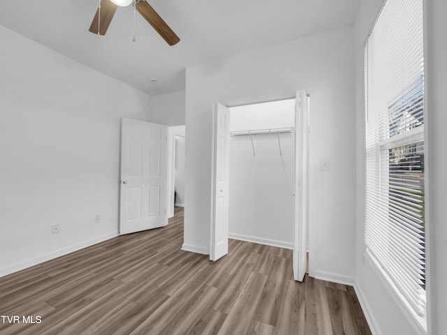 unfurnished bedroom featuring a closet, light hardwood / wood-style floors, and ceiling fan