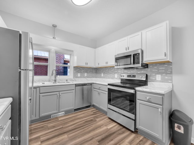 kitchen featuring hardwood / wood-style floors, sink, appliances with stainless steel finishes, and gray cabinets