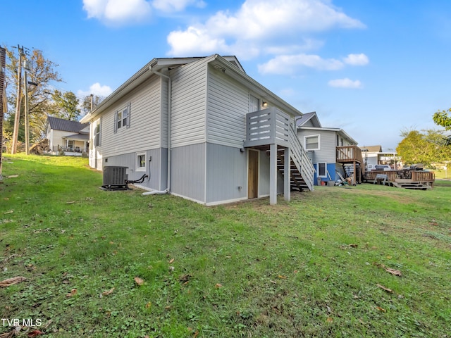 view of property exterior featuring a wooden deck, a yard, and central air condition unit