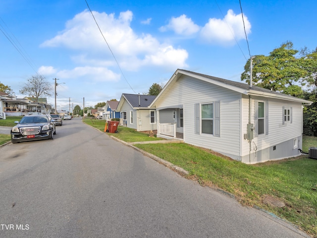 view of front of house with a front lawn and central AC unit