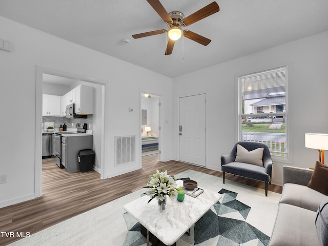 living room with hardwood / wood-style flooring and ceiling fan