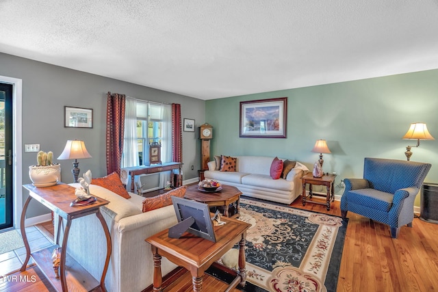 living room featuring light wood-type flooring, a wealth of natural light, and a textured ceiling