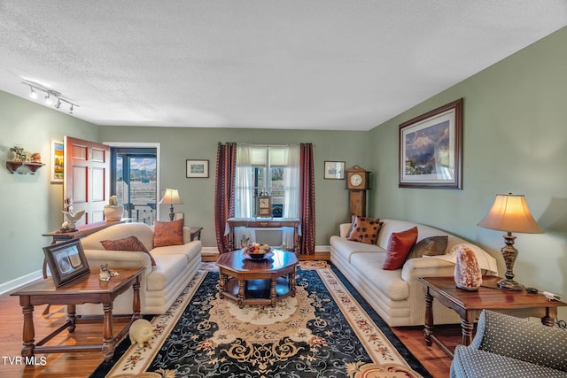 living room with hardwood / wood-style flooring, a textured ceiling, and rail lighting