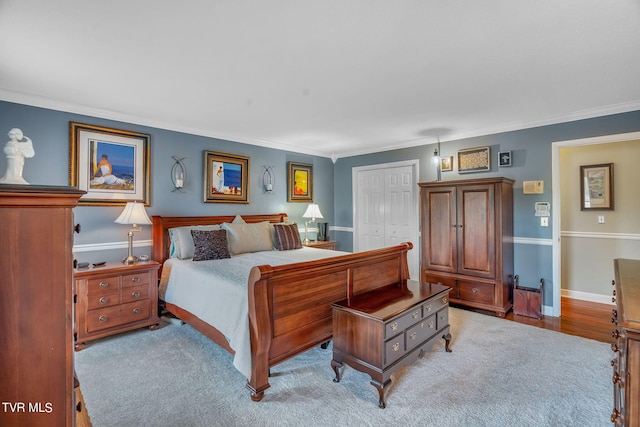 bedroom with light hardwood / wood-style floors, a closet, and ornamental molding