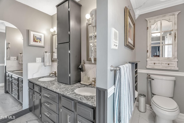 bathroom featuring vanity, crown molding, and toilet