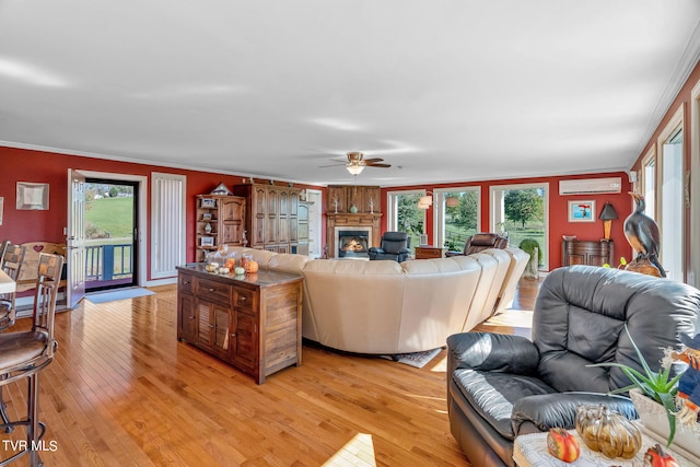 living room featuring ornamental molding, light wood-type flooring, and a wealth of natural light