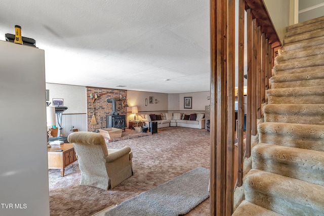 carpeted living room with a textured ceiling and a wood stove