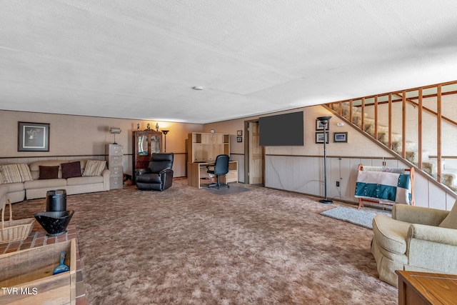 living room featuring a textured ceiling, wood walls, and carpet flooring