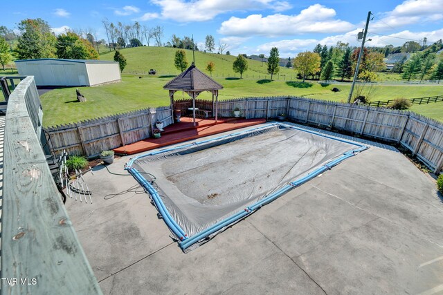 view of pool featuring a rural view, a lawn, and a patio area