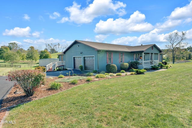 view of front of home with a garage, a porch, and a front lawn