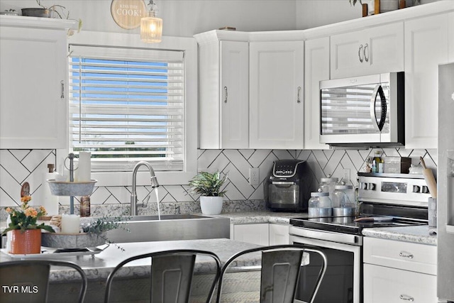 kitchen with stainless steel appliances, sink, and white cabinetry