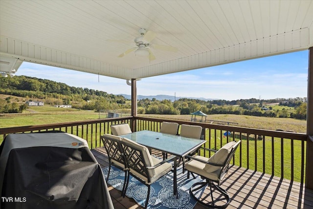 wooden terrace featuring ceiling fan, grilling area, and a yard