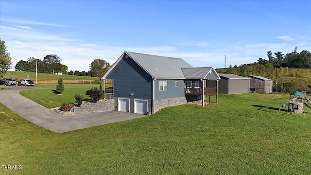 view of property exterior with a garage, a yard, a storage unit, and a deck