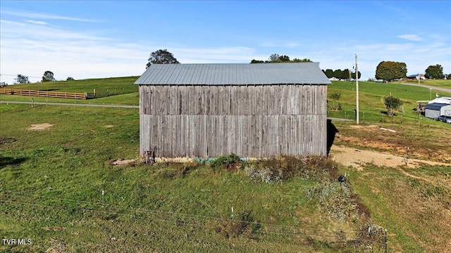 view of outdoor structure featuring a rural view and a lawn