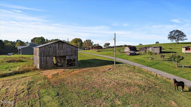 view of yard featuring a rural view and an outbuilding