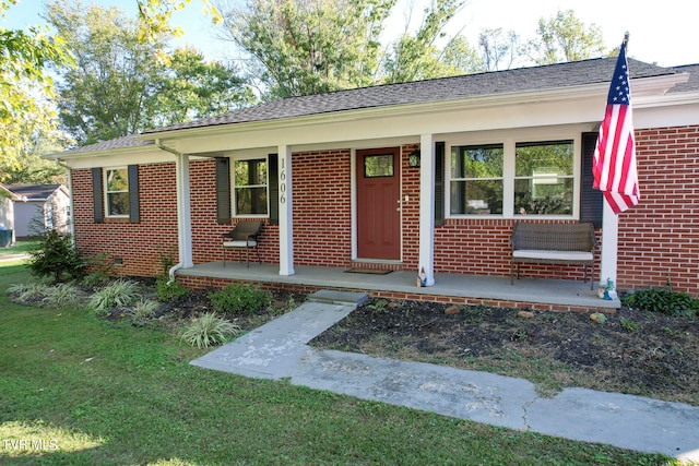 single story home with a front yard and covered porch