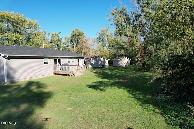 view of yard with a wooden deck and a storage unit