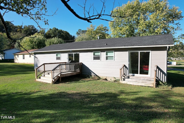 rear view of house featuring a lawn and a deck