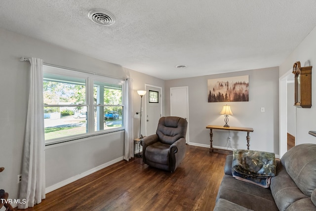 living room with dark hardwood / wood-style floors and a textured ceiling