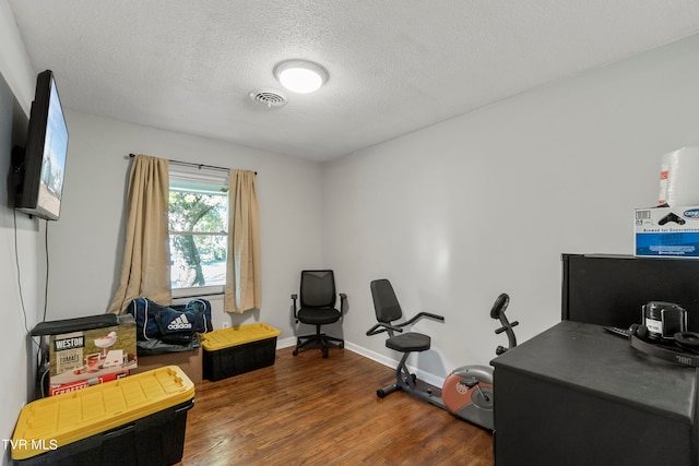 home office with dark wood-type flooring and a textured ceiling