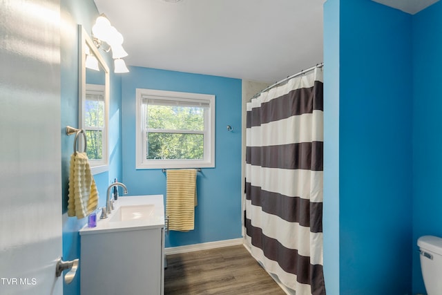 bathroom with hardwood / wood-style flooring, toilet, vanity, and a shower with curtain