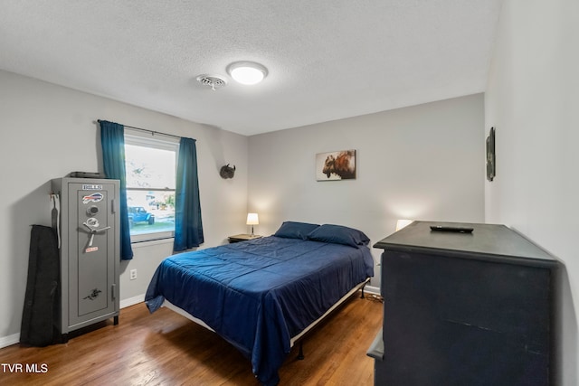 bedroom featuring a textured ceiling and dark wood-type flooring