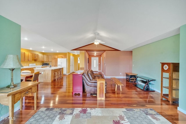 living room with hardwood / wood-style floors, ceiling fan, and lofted ceiling