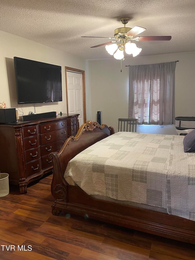 bedroom featuring ceiling fan, dark wood-type flooring, and a textured ceiling