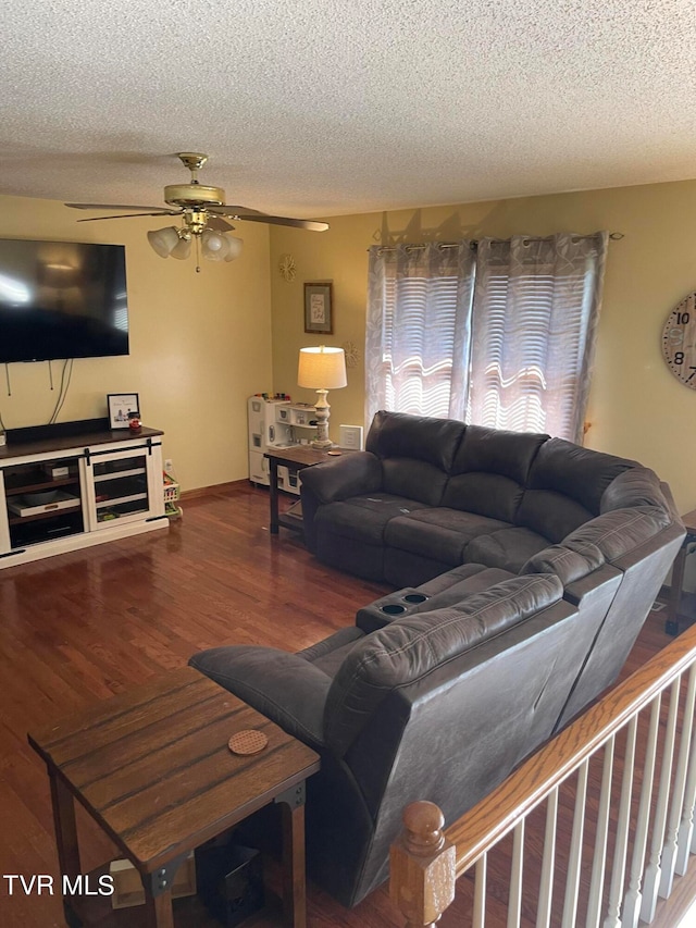 living room with a textured ceiling, ceiling fan, and hardwood / wood-style flooring