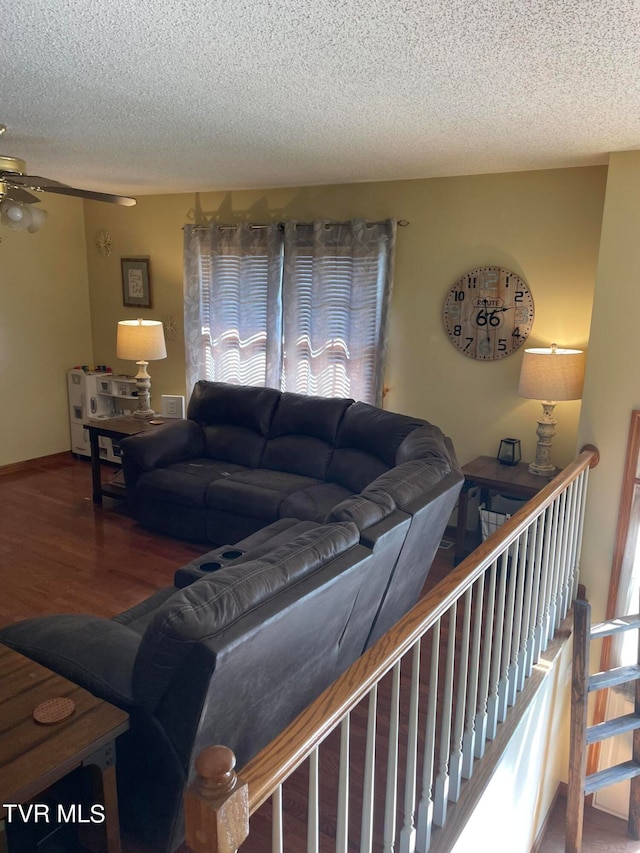 living room with hardwood / wood-style flooring, a textured ceiling, and ceiling fan