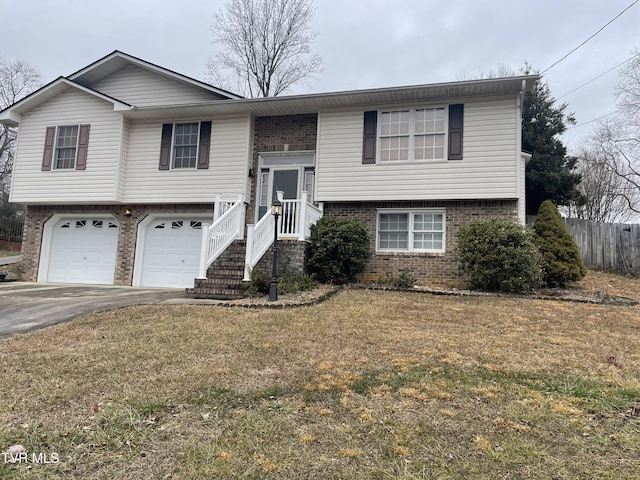 raised ranch with a front lawn and a garage