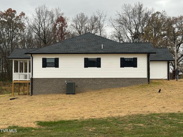 view of side of home with central AC and a lawn