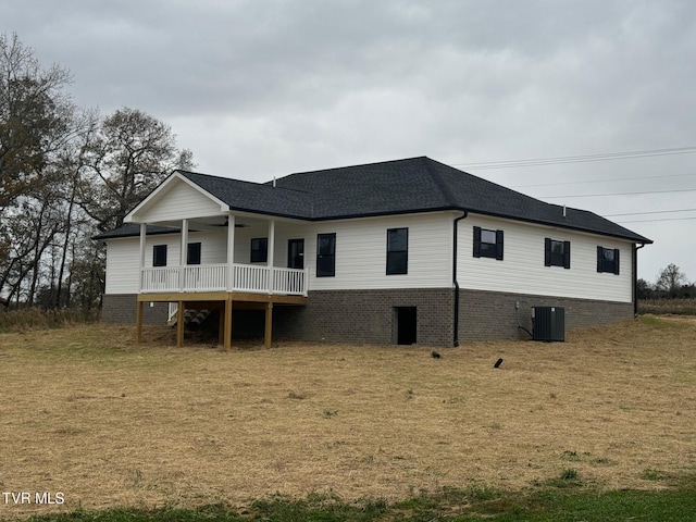 rear view of house with a yard and cooling unit