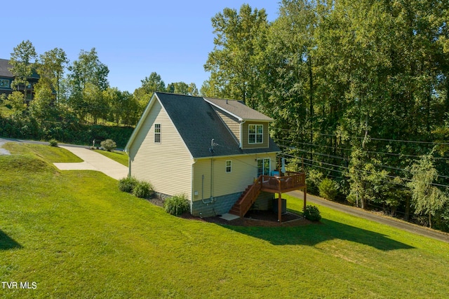 rear view of house featuring a wooden deck and a lawn