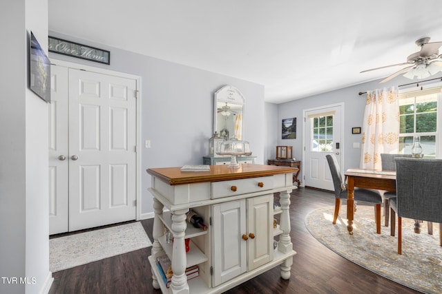 dining area with ceiling fan and dark wood-type flooring